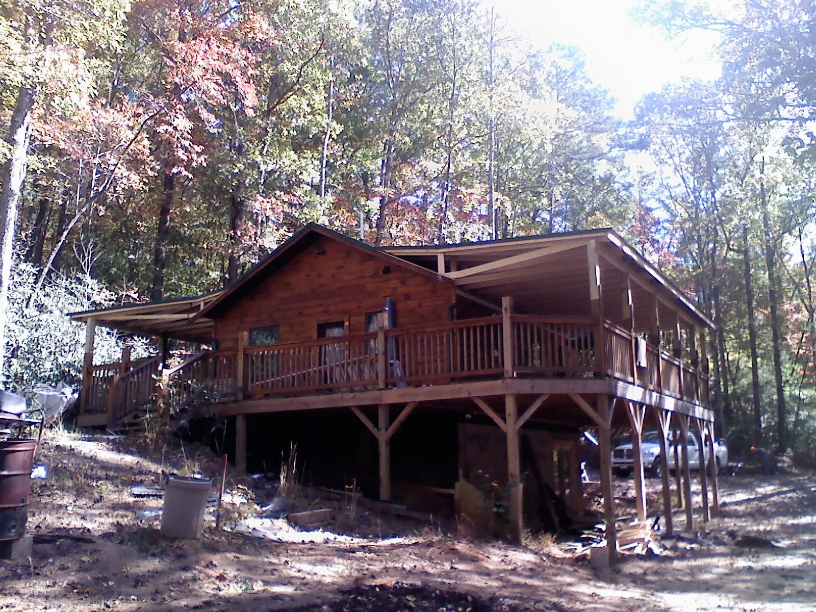 Log cabin with a wraparound porch and metal roof in the fall in Delmar